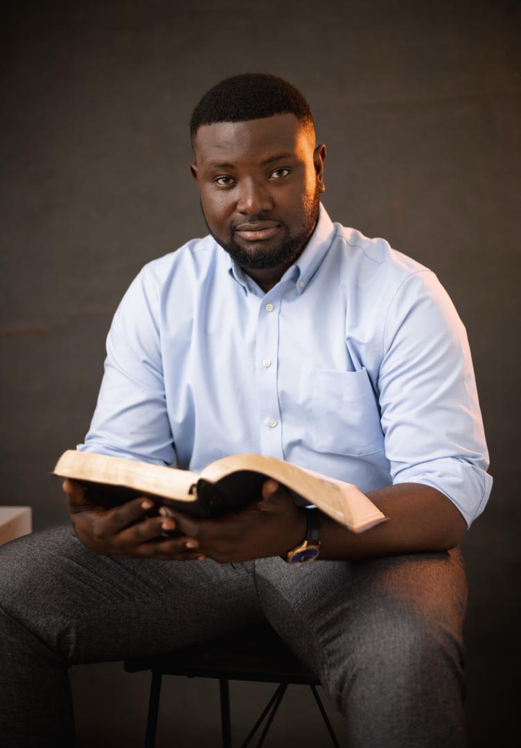 Pastor Clifford Srekumah Gli with an open Bible